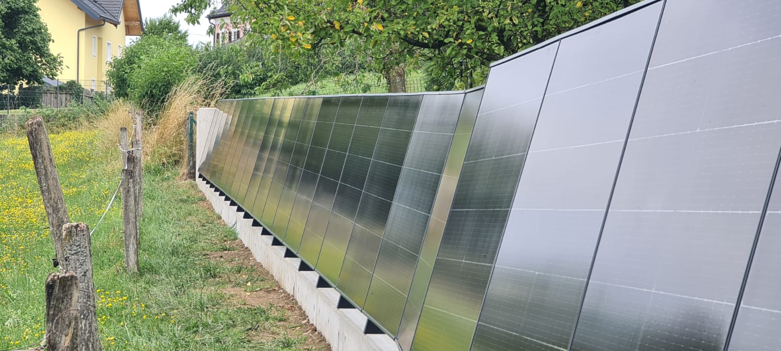 Photovoltaik-Zaun entlang einer Gartenmauer